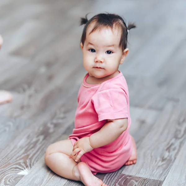 Bella carino bambino kazakh un anno vecchia ragazza sittimg sul pavimento a casa — Foto Stock