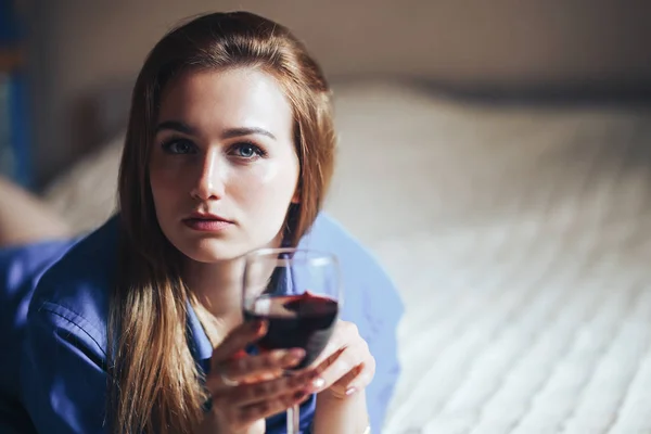 Красивая грустная женщина сидит на полу в рубашке, держать вино она расстроена, одна, никто не любил, без любви — стоковое фото