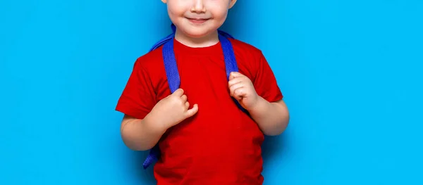 Happy smiling boy in red t-shirt with glasses on his head is going to school for the first time. Child with school bag. Kid on blue background background. Back to school — Stock Photo, Image