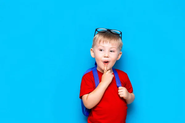 Okula dönüş Kopya alanı ile mavi arka plan üzerinde izole gözlük lü mutlu sürpriz çocuk Portresi. yeni okul bilgileri — Stok fotoğraf