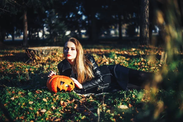 Piękna Nowoczesna wiedźma trzyma halloweenową dynię w lesie. Października. Wesołych Świąt — Zdjęcie stockowe