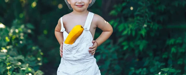 Sarı kabak ile gülerek beyaz giysiler giyen küçük çocuk çiftçi, hasat zamanı — Stok fotoğraf