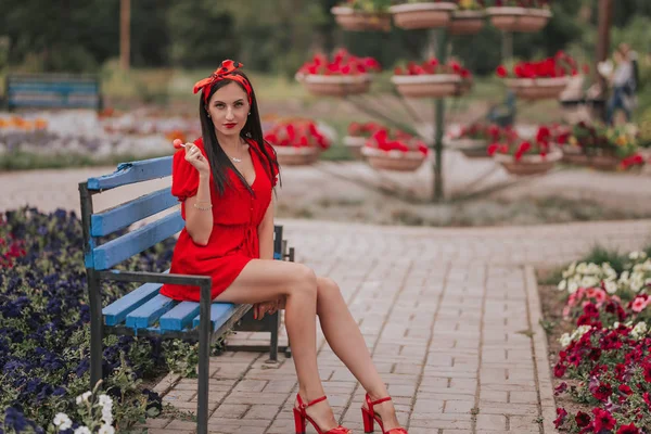 그녀의 손에 롤리팝과 빨간 옷을 입고 섹시한 젊은 여자의 패션 초상화 — 스톡 사진