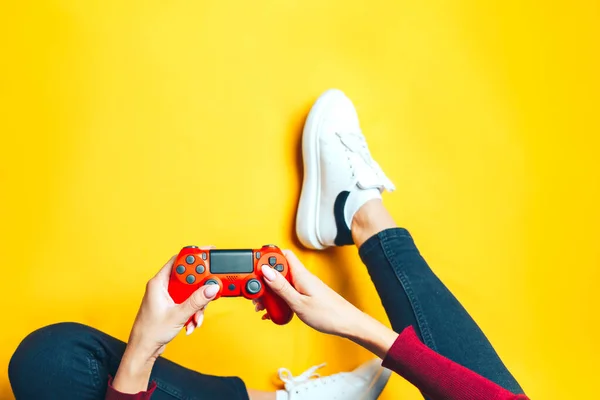 Mujer joven jugando con dos mandos en amarillo . —  Fotos de Stock