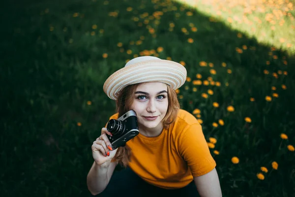 Turuncu Tişörtlü Genç Bir Kız Elinde Retro Kamerayla Çimlere Uzanmış — Stok fotoğraf