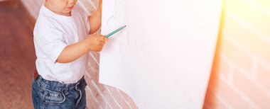 Küçük çocuk kağıda resim çizer, evde eğitim, anaokulu eğitimi..