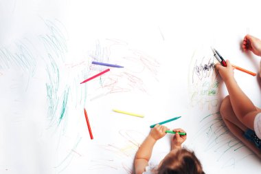 Beyaz kağıda renkli keçeli kalemler çizen yetenekli çocuklar, farklı yaşlardaki çocuklar için dersler, görevler.