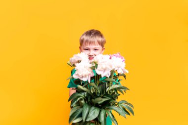 Küçük çocuk elinde bir buket güzel çiçek tutuyor, anneler günü, 8 Mart, babalar günü.