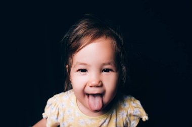 Gülümseyen karışık ulus küçük kız kameraya bakıyor ve gülümsüyor.