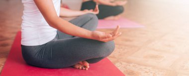 Güzel genç kız minderde yoga yapıyor, rahatlıyor, sağlığıyla ilgileniyor..