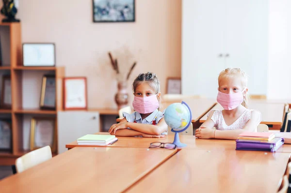 Duas Pequenas Alunas Sentam Uma Mesa Uma Classe Escola Máscaras — Fotografia de Stock