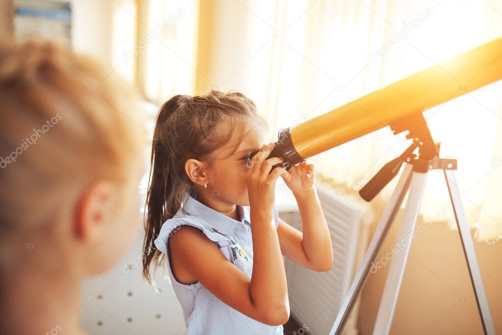 Two schoolgirls are looking through a telescope in an astronomy lesson, back to school, children's education.