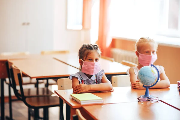 Duas Pequenas Alunas Sentam Uma Mesa Uma Classe Escola Máscaras — Fotografia de Stock