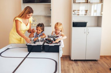 İki liseli kız robotik sınıfında okuyor, bir robot inşaatçısını birleştiriyor..