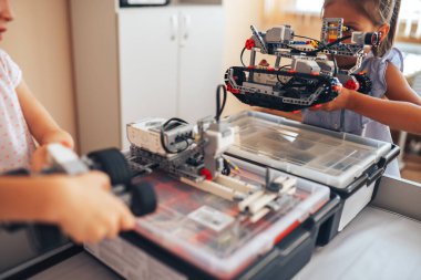 İki liseli kız robotik sınıfında okuyor, bir robot inşaatçısını birleştiriyor..
