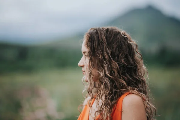 Turuncu Elbiseli Bir Kızın Yakın Plan Fotoğrafı Dağların Arka Planında — Stok fotoğraf