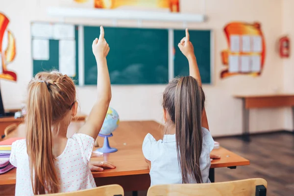 Dos Colegialas Sientan Escritorio Una Clase Escolar Levantan Las Manos —  Fotos de Stock