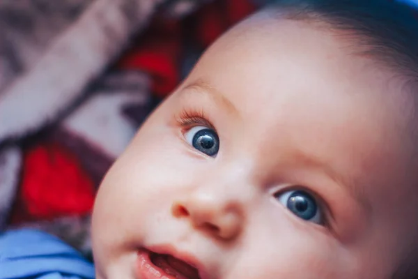 Kameraya bakan bir bebek, mavi gözlü ve sarı saçlı yeni doğmuş bir bebek. — Stok fotoğraf