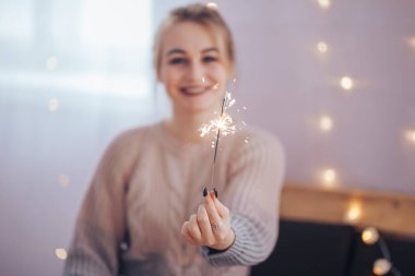 Elinde maytap tutan genç kız Noel 'in gelişinden çok mutlu, Mutlu Noeller ve mutlu yıllar..