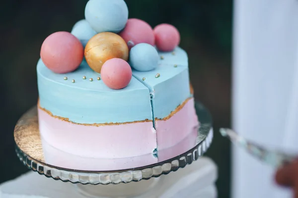 Two-tier cake is two-tone, the bottom of the cake is pink and the top is blue, the cake has different balls.