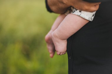 Yeni doğmuş bebek açık havada ebeveynlerin kollarında..