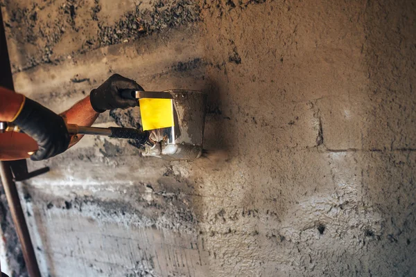 Man gips een muur met mortel met behulp van een hopper emmer — Stockfoto