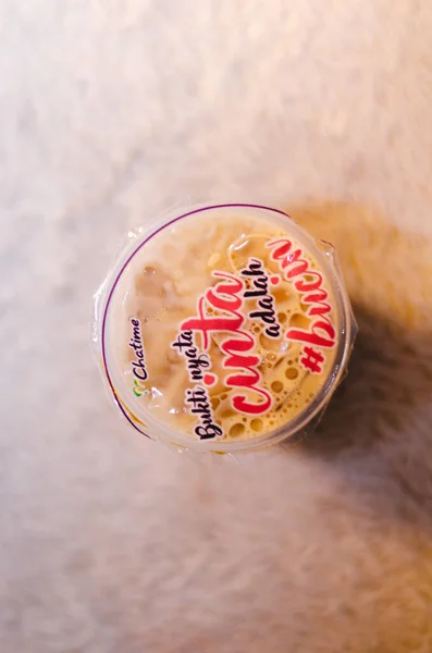 Chatime franchise 'den Brown Sugar Taze Süt Çayı' nın resmedilmiş bir başyazısı. Bahasa Endonezya 'da yazılmış ifadenin üst görüşü ile birlikte..