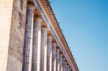 Öğleden sonra sütunları ve temiz gökyüzü olan büyük bir mimari binanın yan açısı..