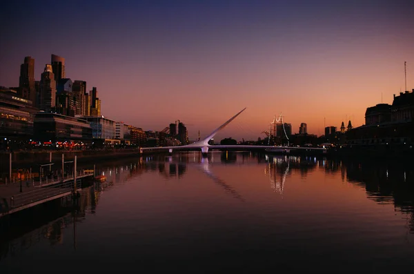 Buenos Aires, Arjantin - 6 Eylül 2018: Günbatımında Rio de la Plata üzerinde Puente de la Mujer isimli ikonik köprü ile Buenos Aires 'in iş bölgesi.