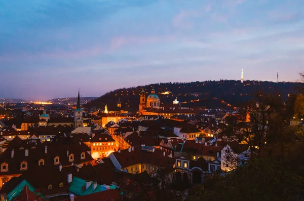 Prag, Çek Cumhuriyeti - Başkentin aydınlık sokaklarının ve alacakaranlıktaki kahverengi çatılarının büyülü bir manzarası.