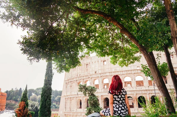Roma, İtalya - 20 'li yaşlarda kızıl saçlı genç Brezilyalı bir kadın öğleden sonra bir parkta çekilen kolezyumu araştırıyor..