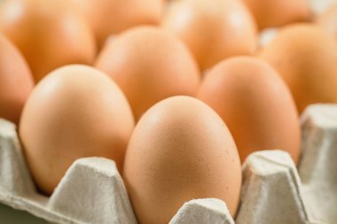 Yumurta rafındaki taze yumurtalar ahşap masaya kondu. Tavuk yumurtalarını pişirme ya da ahşap masa üzerinde fırın için hazırlayın. Seçici odak kavramı ile kapatın Arka plan veya duvar kağıdı için kopyalama alanı olan taze yumurtalar.