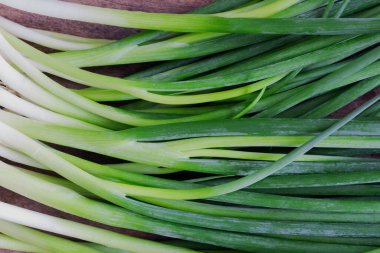 Köy ahşap masada taze taze taze soğan. Ya soğanları kapat ya da tahta üzerine taze soğan koy. Taze soğanı pişirmeye hazırlayın. Arkaplan veya duvar kağıdı için gıda ve sebze kavramı.