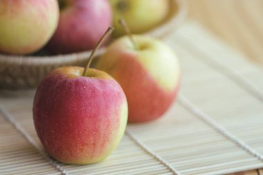 Sepette Fuji elması yığını ve arka plan veya duvar kağıdı için ahşap masanın üzerinde. Salata pişirme veya fırın için uygun lezzetli ve sulu Fuji elması. Fuji elmasının kökeni Japonya 'dır..