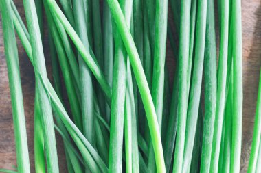 Köy ahşap masada taze taze taze soğan. Callion yaprağının üzerine yakın ya da en üstteki düz yerde taze soğan. Taze soğanı pişirmeye hazırlayın. Arkaplan veya duvar kağıdı için gıda ve sebze kavramı.