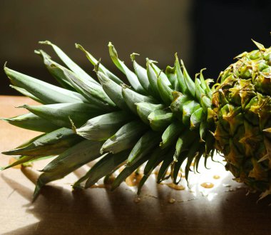 Masanın üzerinde sulu bir kapağı olan olgun ananas. Yakın plan.