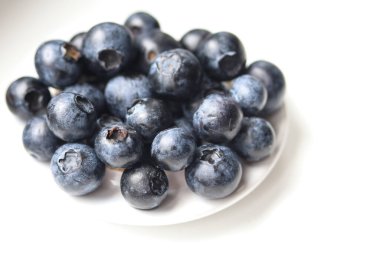 Hafif arka plan makro fotoğrafında taze, sulu yabanmersini.