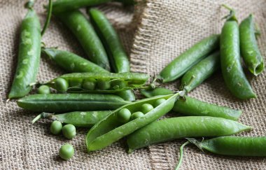 Çuval bezi arkaplanındaki yeşil bezelyeler