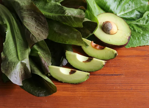 Tahta Bir Masanın Üzerinde Olgun Avokado Marul Yaprakları — Stok fotoğraf