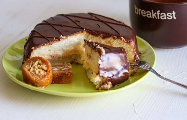 Çikolatalı kek ve baklava yeşil tabakta, beyaz arka planda.