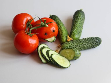 Beyaz arka planda taze salatalık ve domatesler.