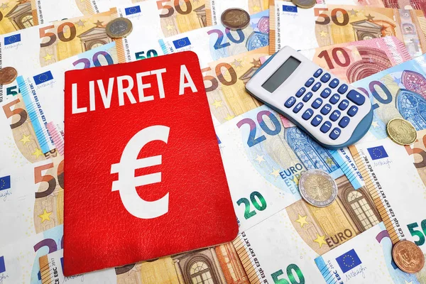 Livret A ve hesap makinesi Avro banknotları ve madeni paraların üstünde. Livret A, Fransız bankalarının sunduğu tarihi bir finansal üründür..