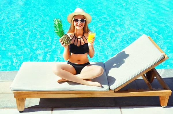 yaz tatili - mutlu kadın gülümsüyor ananas ile mavi su havuzu arka plan üzerinde bir şezlong ananas ile bardakta meyve suyu
