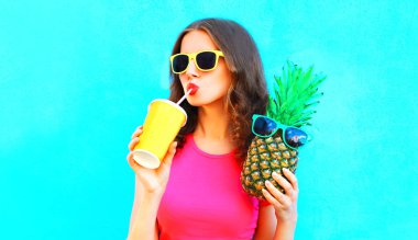 Ananas suyu bardaktan renkli arka plan üzerinde içme ile güzel kadın