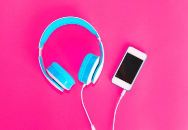 Kulaklık ve pembe bir arka plan üzerinde smartphone