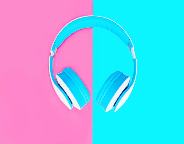 Headphones over colorful pink blue background top view