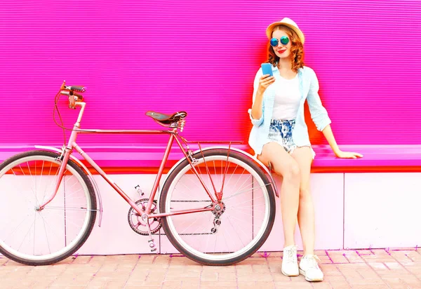 Νεαρή Γυναίκα Χρησιμοποιώντας Smartphone Ρετρό Ποδήλατο Πάνω Από Πολύχρωμα Ροζ — Φωτογραφία Αρχείου