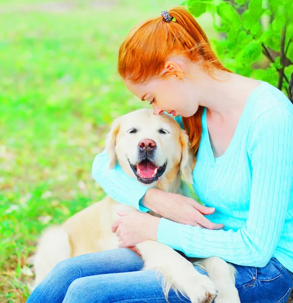 所有者の女性は 草の上彼女のゴールデン リトリーバー犬を抱いています — ストック写真