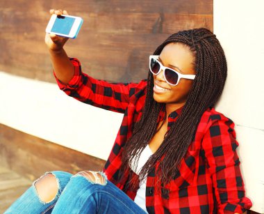 Serin kız alıyor Smartphone cep telefonu ile şehirde eğleniyor kendi kendine portre resim