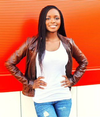 City adlı kırmızı arka plan üzerinde poz ceketli güzel Afrikalı kadın